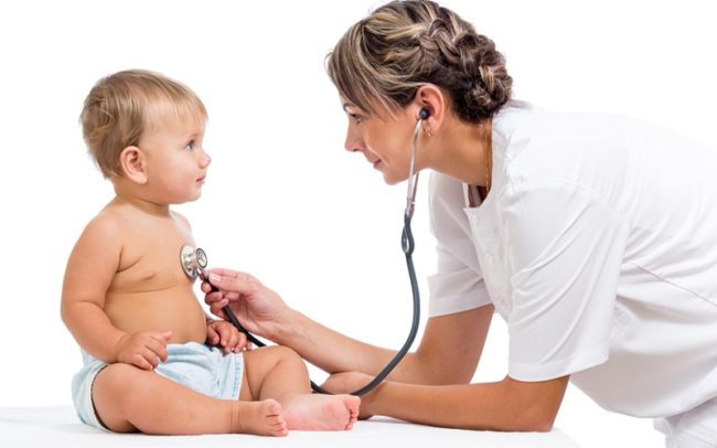 Детский врач педиатр слушает стетоскопом новорождённого ребёнка