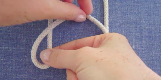 Левой рукой возьмите свободный конец верёвки и наложите поверх натянутой