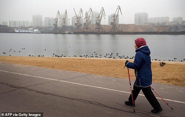 A woman walks along the Channel of Moscow in the capital on December 26 during the unusually warm weather