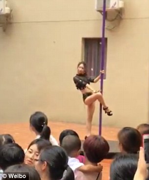 Video of the bizarre arrangement shows a woman in skimpy clothing and high platform shoes spinning around a pole on a small stage as confused three- to six-year-olds looked on