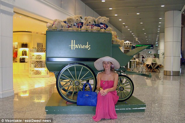 Ms Borodina is pictured next to a wagon with the label Harrods in a shopping mall