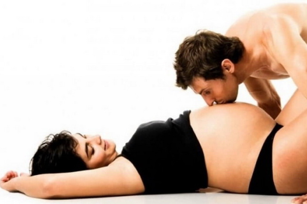 мужчина целует живот беременной