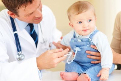 врач осматривает маленького ребенка