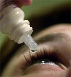 Person putting eyedrops in eyes.